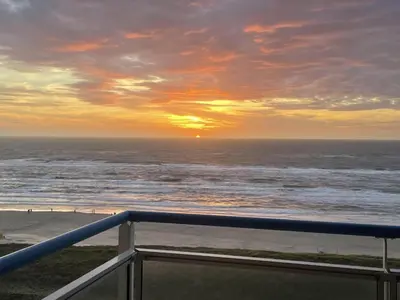 a view of the ocean at sunset from a balcony at Sterflat 207 in Egmond aan Zee