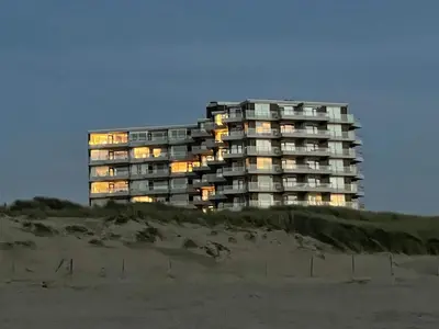 a large apartment building on the beach at night at Sterflat 207 in Egmond aan Zee