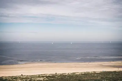 a view of a beach with people in the water at Sterflat 219 in Egmond aan Zee