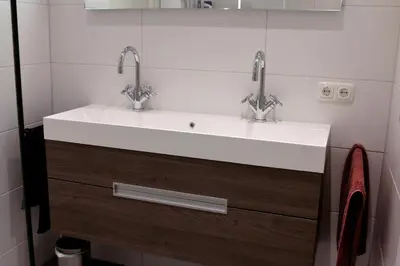 a bathroom with a white sink and two faucets at Sterflat 219 in Egmond aan Zee