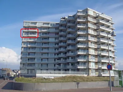a tall apartment building with a red circle on it at Sterflat 219 in Egmond aan Zee