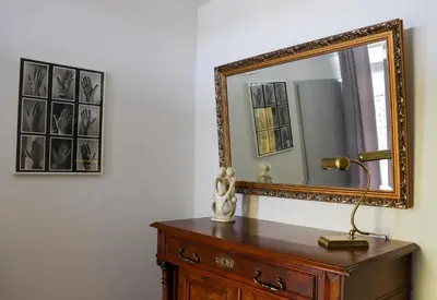 a mirror on top of a wooden dresser with a lamp at Sterflat 223 in Egmond aan Zee