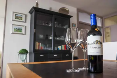 a bottle of wine and two wine glasses on a table at Sterflat 223 in Egmond aan Zee