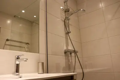a shower in a bathroom with a sink at Sterflat 223 in Egmond aan Zee