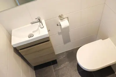 a bathroom with a white toilet and a sink at Sterflat 223 in Egmond aan Zee