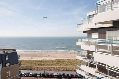 a view of the beach from the balcony of a building at Sterflat 223 in Egmond aan Zee