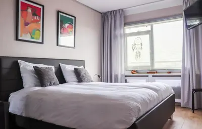 a bedroom with a large bed and a window at Sterflat 223 in Egmond aan Zee