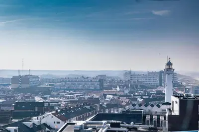 a view of a city with a lighthouse at Sterflat 227 in Egmond aan Zee