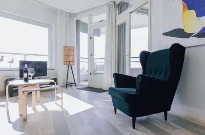 a living room with a chair and a table at Sterflat 227 in Egmond aan Zee