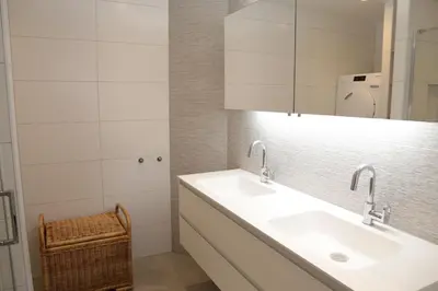a bathroom with a sink and a mirror at Sterflat 241 in Egmond aan Zee