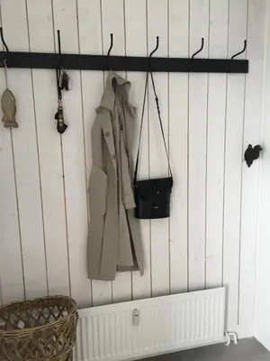 a rack with coats and a purse on a wall at Sterflat 241 in Egmond aan Zee