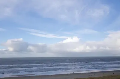 a view of the ocean with people on the beach at Sterflat 241 in Egmond aan Zee