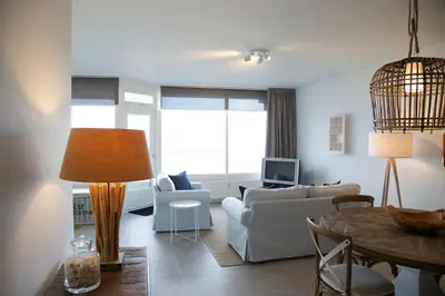 a living room with a couch and a table at Sterflat 241 in Egmond aan Zee