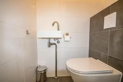 a bathroom with a toilet and a sink at Sterflat 249 in Egmond aan Zee
