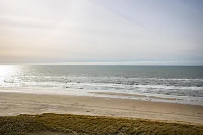 an empty beach with the ocean in the background at Sterflat 249 in Egmond aan Zee