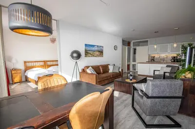 a living room with a dining table and a living room at Sterflat 249 in Egmond aan Zee
