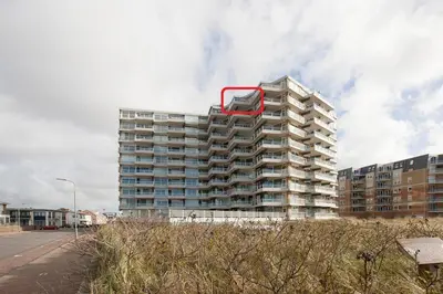 a tall apartment building with a red at Sterflat 259 in Egmond aan Zee
