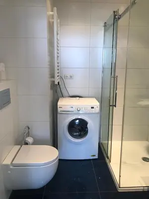 a bathroom with a toilet and a washing machine at Sterflat 259 in Egmond aan Zee