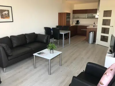 a living room with a couch and a table at Sterflat 259 in Egmond aan Zee