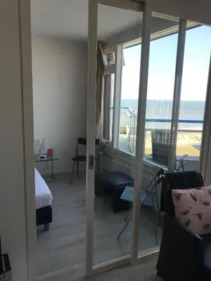 a room with a view of a bedroom with a view of the ocean at Sterflat 259 in Egmond aan Zee