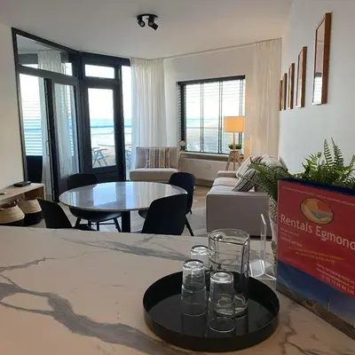 a living room with a table with glasses on a tray at Sterflat 261 in Egmond aan Zee