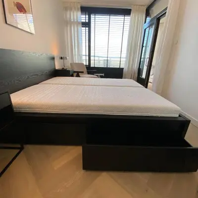 a bedroom with a large bed in a room at Sterflat 261 in Egmond aan Zee