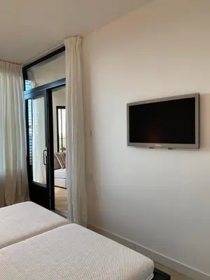 a bedroom with a flat screen tv on the wall at Sterflat 261 in Egmond aan Zee