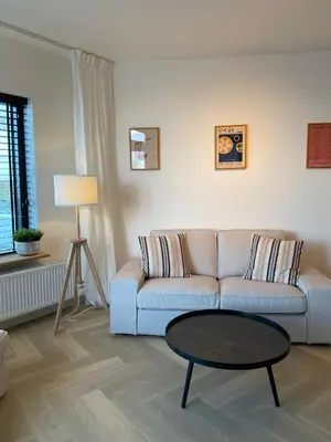 a living room with a couch and a table at Sterflat 261 in Egmond aan Zee