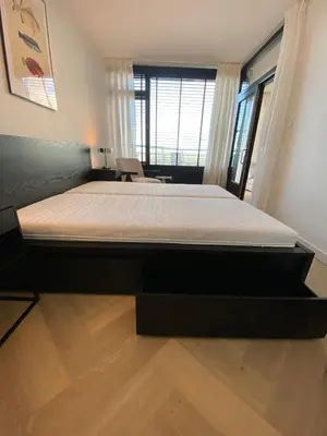 a bedroom with a large bed in a room at Sterflat 261 in Egmond aan Zee