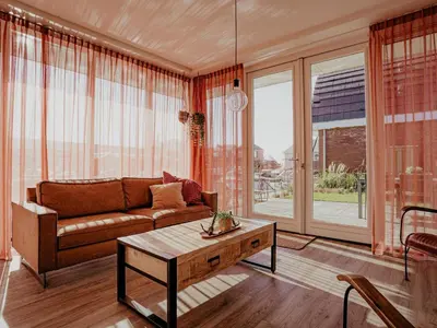a living room with a couch and a table at Modern Waterfront Retreat in Uitgeest
