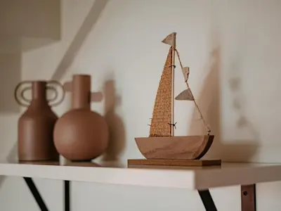 a small wooden boat sitting on a shelf with vases at Modern Waterfront Retreat in Uitgeest