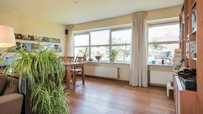 a living room with a table and some windows at Huize Bech in Bergen