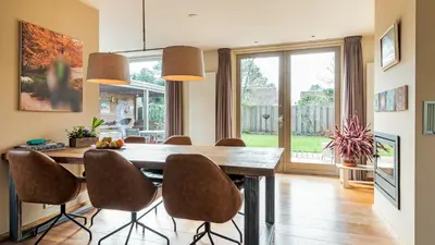 a dining room with a wooden table and chairs at Huize Bech in Bergen