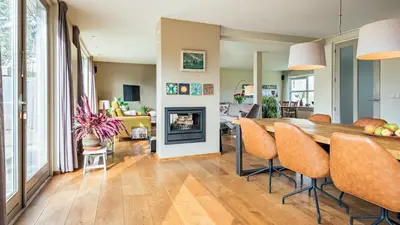 a kitchen and living room with a table and a fireplace at Huize Bech in Bergen