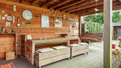 a wooden cabin with a clock on the wall at Huize Bech in Bergen