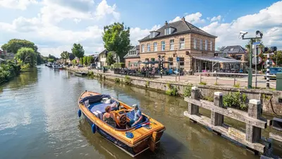 a group of people in a boat on a river at Hotel Over de Brug in Haastrecht