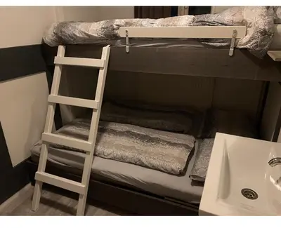a bunk bed with a ladder next to a sink at Halte71 in Zandvoort