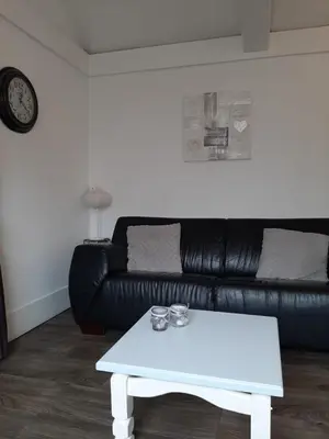 a white coffee table in a living room with a black couch at Halte71 in Zandvoort
