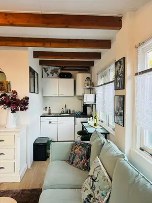 a living room with a couch and a kitchen at Hello Noordwijk - Tiny House Dahliastraat 60 in Noordwijk aan Zee