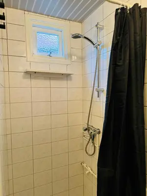 a bathroom with a shower and a window at Hello Noordwijk - Tiny House Dahliastraat 60 in Noordwijk aan Zee