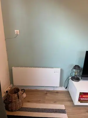a room with a blue wall and a radiator at Hello Noordwijk - Tiny House Dahliastraat 60 in Noordwijk aan Zee