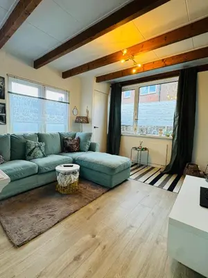 a living room with a couch and a table at Hello Noordwijk - Tiny House Dahliastraat 60 in Noordwijk aan Zee