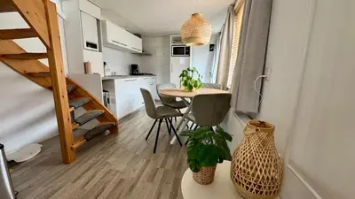 a small kitchen and dining room with a small table in a tiny house at Vakantiehuis Voor Anker in Egmond aan Zee