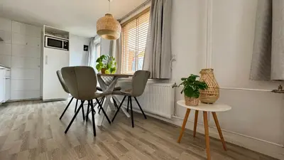 a dining room with a table and two chairs at Vakantiehuis Voor Anker in Egmond aan Zee