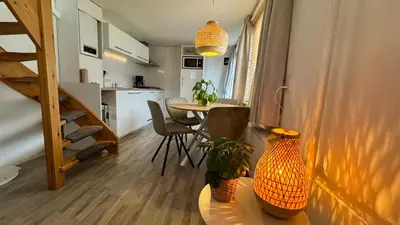 a small apartment with a table and a kitchen at Vakantiehuis Voor Anker in Egmond aan Zee