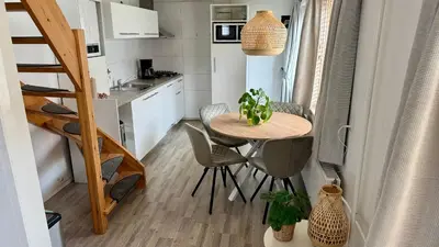 a small kitchen with a table in a tiny apartment at Vakantiehuis Voor Anker in Egmond aan Zee