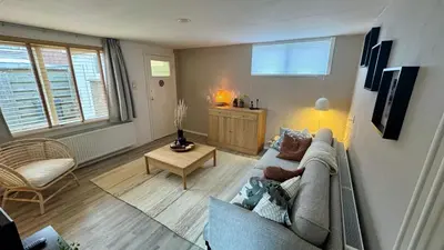 a living room with a couch and a table at Vakantiehuis Voor Anker in Egmond aan Zee