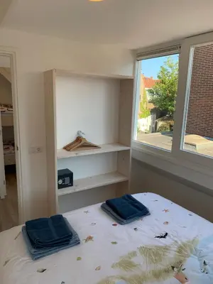 a bedroom with a bed with two blue towels on it at Hello Noordwijk - Familiehuis Quarles van Uffordstraat 77 in Noordwijk aan Zee