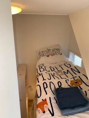 a small bedroom with a bed with a cat comforter at Hello Noordwijk - Familiehuis Quarles van Uffordstraat 77 in Noordwijk aan Zee