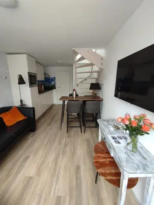 a living room with a table with a vase of flowers at Hello Noordwijk - Familiehuis Quarles van Uffordstraat 77 in Noordwijk aan Zee